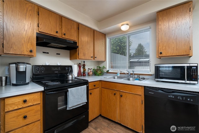 811 S Laventure Rd Unit C, Mount Vernon, WA 98274 - kitchen featuring black appliances, under cabinet range hood, a sink, light countertops, and wood finished floors