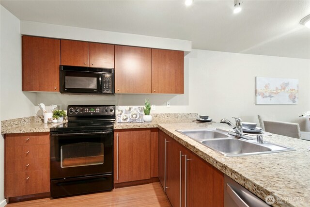 11309 NE 128th St Unit F302, Kirkland, WA 98034 - kitchen featuring black appliances, a sink, light wood finished floors, light countertops, and brown cabinetry