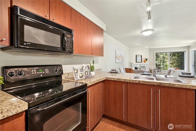 11309 NE 128th St Unit F302, Kirkland, WA 98034 - kitchen featuring black appliances, a sink, light countertops, brown cabinets, and light wood finished floors
