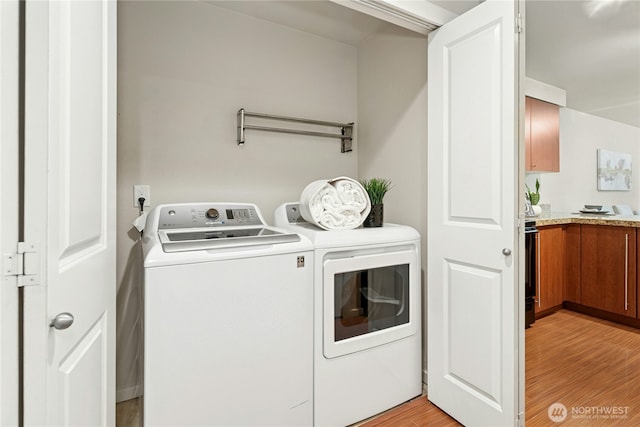 11309 NE 128th St Unit F302, Kirkland, WA 98034 - laundry room featuring washer and clothes dryer and light wood-style flooring