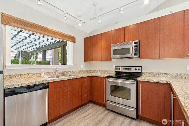 11309 NE 128th St Unit F302, Kirkland, WA 98034 - kitchen with appliances with stainless steel finishes, light wood-style floors, brown cabinetry, and a sink