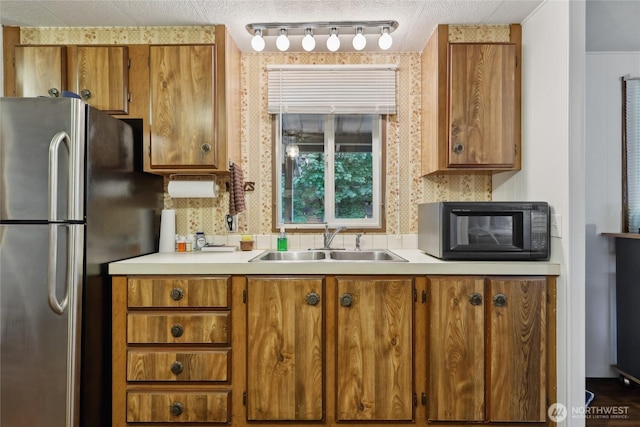 35605 158th St SE, Sultan, WA 98294 - kitchen with freestanding refrigerator, a sink, black microwave, and brown cabinetry