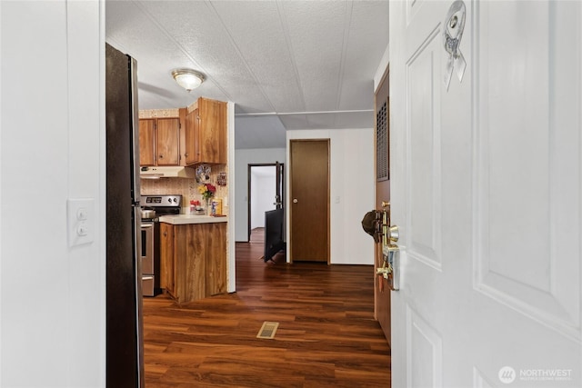35605 158th St SE, Sultan, WA 98294 - kitchen with stainless steel range with electric stovetop, brown cabinetry, dark wood-style floors, under cabinet range hood, and light countertops