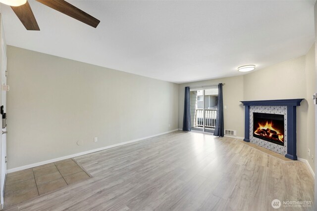 1132 N 198th St Unit C204, Shoreline, WA 98133 - unfurnished living room with a fireplace with flush hearth, wood finished floors, and a ceiling fan