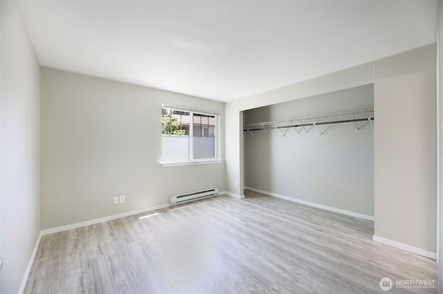 1132 N 198th St Unit C204, Shoreline, WA 98133 - unfurnished bedroom featuring a baseboard heating unit, wood finished floors, and a closet