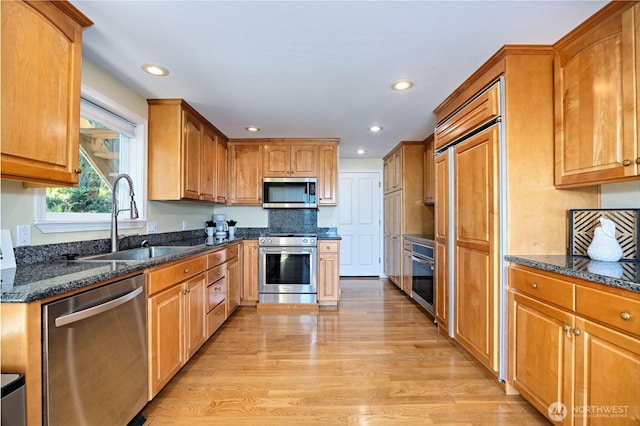 873 Olele Point Rd, Port Ludlow, WA 98365 - kitchen with premium appliances, a sink, light wood-style floors, recessed lighting, and dark stone countertops