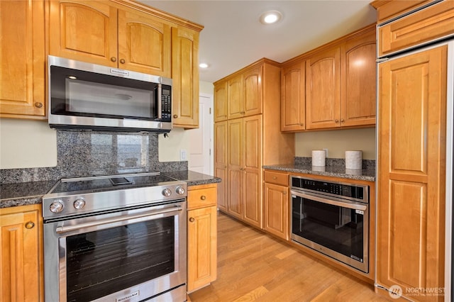 873 Olele Point Rd, Port Ludlow, WA 98365 - kitchen with appliances with stainless steel finishes, light wood-type flooring, recessed lighting, decorative backsplash, and dark stone countertops