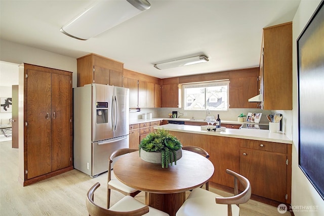 6424 32nd Ave S, Seattle, WA 98118 - kitchen featuring stainless steel fridge with ice dispenser, light wood-type flooring, light countertops, and a peninsula