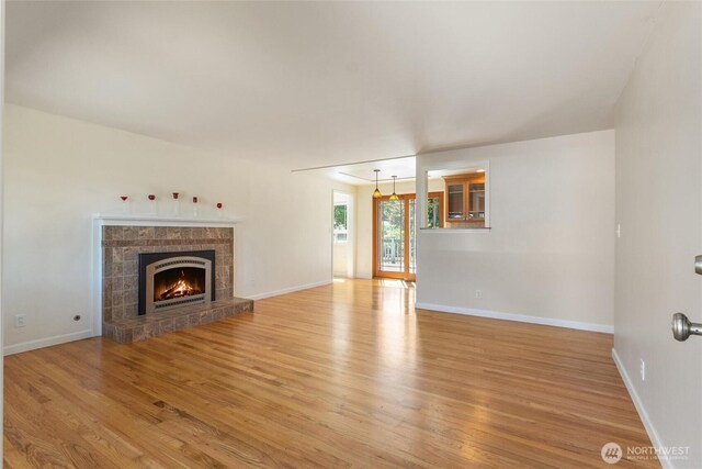 10502 240th Pl SW, Edmonds, WA 98020 - unfurnished living room featuring light wood-style floors, a stone fireplace, and baseboards