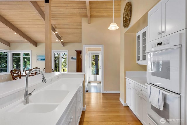 1794 Bayshore Rd, Lopez Island, WA 98261 - kitchen featuring double oven, wooden ceiling, a sink, white cabinetry, and light wood-style floors