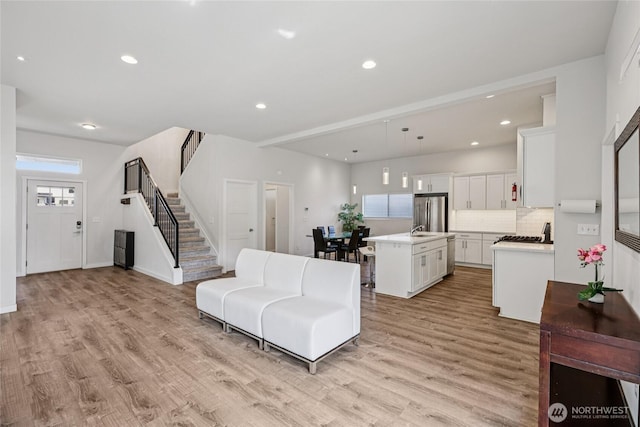 7724 16th Ave SW, Seattle, WA 98106 - living room featuring stairway, light wood-style floors, recessed lighting, and baseboards