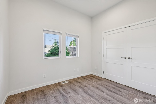 7724 16th Ave SW, Seattle, WA 98106 - unfurnished bedroom with wood finished floors, baseboards, and a closet