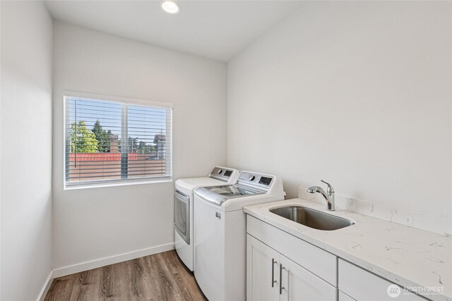 7724 16th Ave SW, Seattle, WA 98106 - washroom with washing machine and dryer, cabinet space, light wood-style floors, baseboards, and recessed lighting