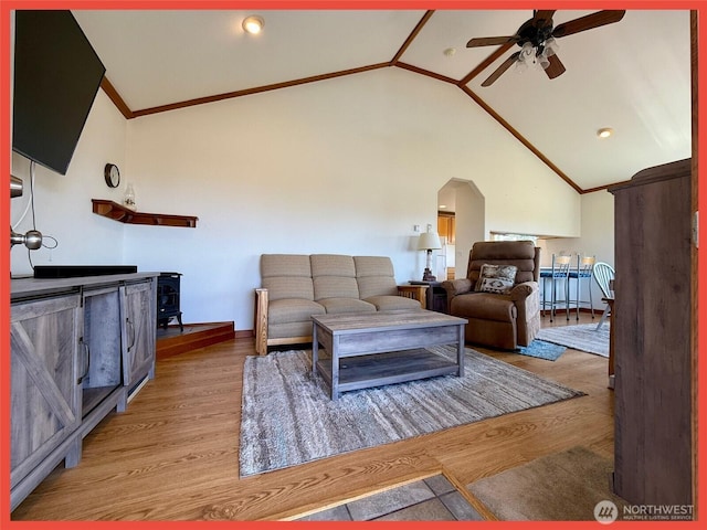 486 Winlock St, Ocean Shores, WA 98569 - living area with a ceiling fan, a wood stove, lofted ceiling, wood finished floors, and arched walkways