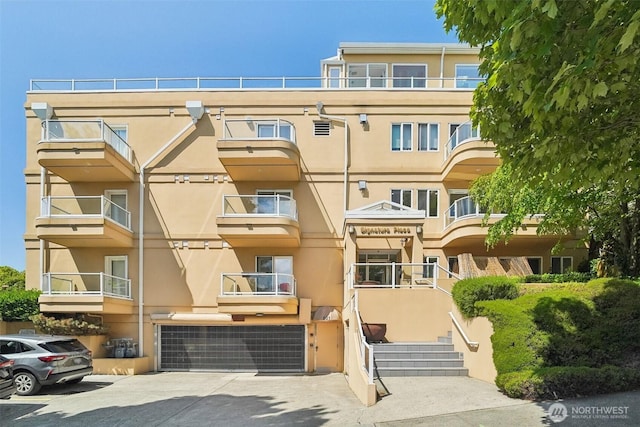 801 2nd Ave N Unit 204, Seattle, WA 98109 - view of apartment building / complex featuring an attached garage, stairway, and concrete driveway