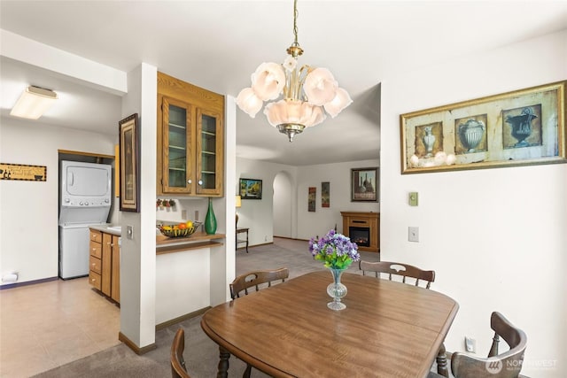 625 N Jackson Ave Unit A9, Tacoma, WA 98406 - dining room with stacked washer and clothes dryer, a chandelier, arched walkways, baseboards, and a fireplace