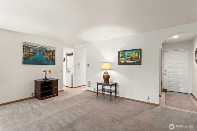 625 N Jackson Ave Unit A9, Tacoma, WA 98406 - sitting room with stacked washer / dryer, arched walkways, carpet floors, and baseboards