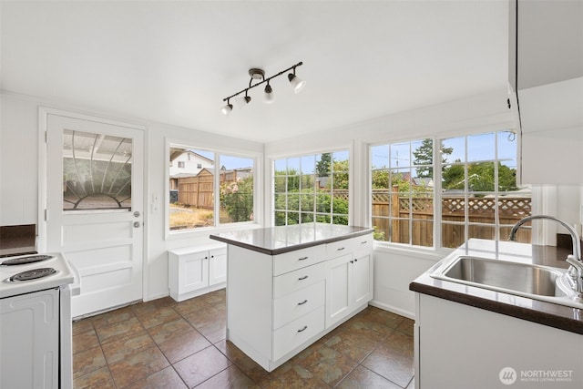 3586 E L St, Tacoma, WA 98404 - kitchen featuring a sink, white electric stove, plenty of natural light, and white cabinetry