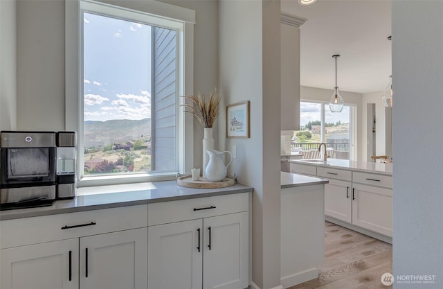 107 Lone Ram Ln, Wenatchee, WA 98801 - kitchen featuring light wood-type flooring, white cabinets, light countertops, pendant lighting, and a mountain view