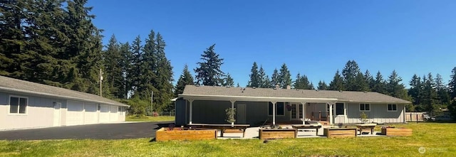 4012 267th St E, Spanaway, WA 98387 - rear view of property featuring a garden, a yard, a garage, and a sunroom