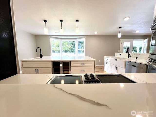 4012 267th St E, Spanaway, WA 98387 - kitchen with appliances with stainless steel finishes, beverage cooler, a sink, light stone counters, and white cabinetry