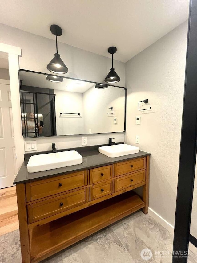 4012 267th St E, Spanaway, WA 98387 - bathroom featuring double vanity, baseboards, and marble look tile flooring