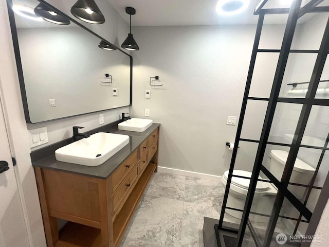 4012 267th St E, Spanaway, WA 98387 - bathroom with marble look tile flooring, double vanity, baseboards, and toilet