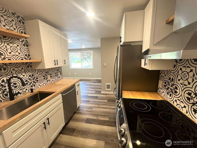 4012 267th St E, Spanaway, WA 98387 - kitchen with open shelves, butcher block countertops, stainless steel appliances, a sink, and wall chimney range hood