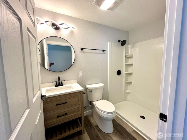 4012 267th St E, Spanaway, WA 98387 - full bathroom featuring vanity, wood finished floors, toilet, a textured ceiling, and a shower