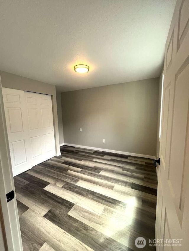 4012 267th St E, Spanaway, WA 98387 - unfurnished bedroom featuring a closet, dark wood-style floors, and baseboards