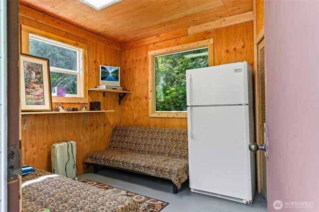 60018 Index Galena Rd, Sultan, WA 98294 - kitchen featuring freestanding refrigerator, radiator heating unit, plenty of natural light, and wood walls