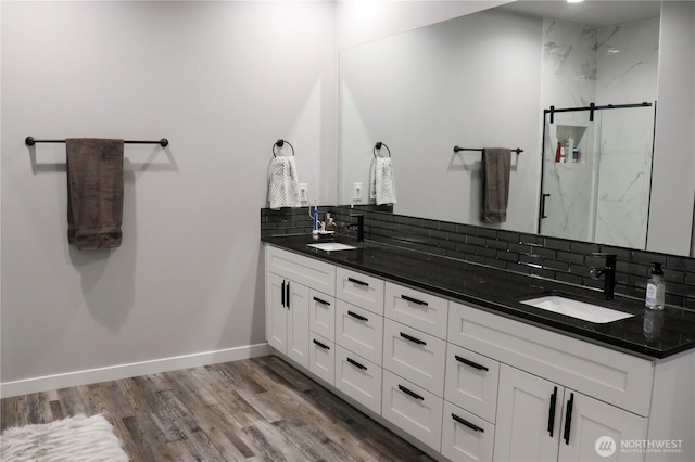 6354 Murray Way NE, Moses Lake, WA 98837 - bathroom featuring double vanity, a marble finish shower, decorative backsplash, wood finished floors, and baseboards