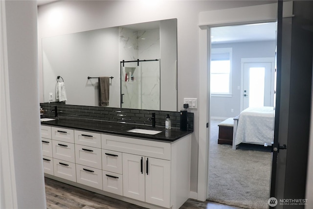 6354 Murray Way NE, Moses Lake, WA 98837 - ensuite bathroom with double vanity, a marble finish shower, wood finished floors, backsplash, and baseboards