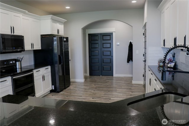 6354 Murray Way NE, Moses Lake, WA 98837 - kitchen featuring black microwave, double oven range, arched walkways, refrigerator with ice dispenser, and backsplash
