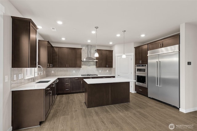 13487 NE 105th Ct Unit 11, Kirkland, WA 98033 - kitchen with appliances with stainless steel finishes, wall chimney range hood, a center island, dark brown cabinets, and a sink