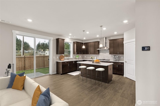 13487 NE 105th Ct Unit 11, Kirkland, WA 98033 - kitchen featuring wall chimney range hood, dark brown cabinetry, light countertops, dark wood-style floors, and open floor plan