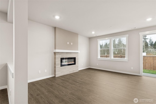 13487 NE 105th Ct Unit 11, Kirkland, WA 98033 - unfurnished living room with a tile fireplace, dark wood-type flooring, recessed lighting, and baseboards