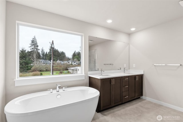13487 NE 105th Ct Unit 11, Kirkland, WA 98033 - full bathroom featuring a freestanding tub, double vanity, baseboards, a shower, and recessed lighting