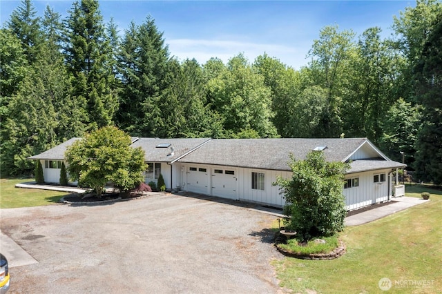 1902 Tellkamp Rd NE, Olympia, WA 98506 - view of front of property with board and batten siding, dirt driveway, an attached garage, and a front lawn