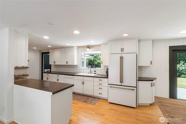 1902 Tellkamp Rd NE, Olympia, WA 98506 - kitchen with white appliances, a sink, dark countertops, light wood-style floors, and backsplash