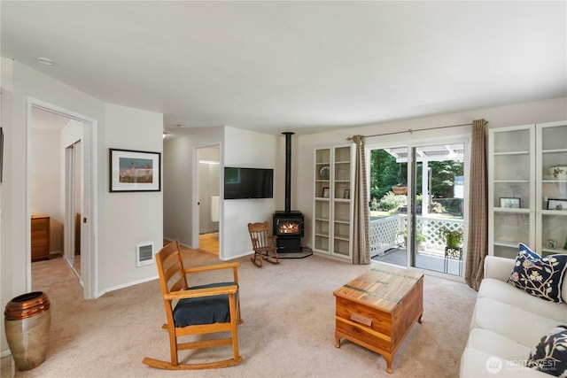1902 Tellkamp Rd NE, Olympia, WA 98506 - living area with a wood stove, light carpet, and baseboards