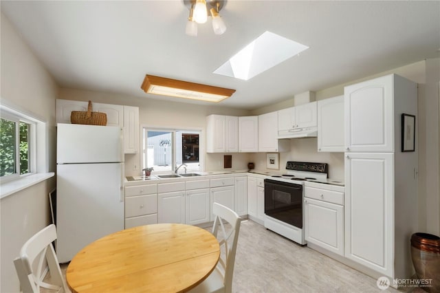 1902 Tellkamp Rd NE, Olympia, WA 98506 - kitchen with freestanding refrigerator, range with electric stovetop, under cabinet range hood, a skylight, and a sink