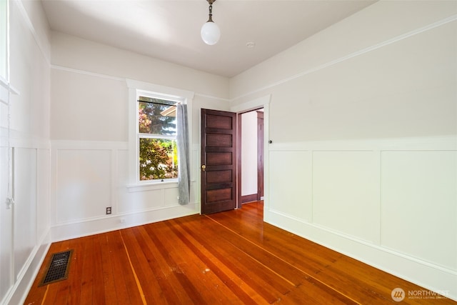 5626 Roosevelt Way NE, Seattle, WA 98105 - empty room featuring a decorative wall, hardwood / wood-style floors, and wainscoting