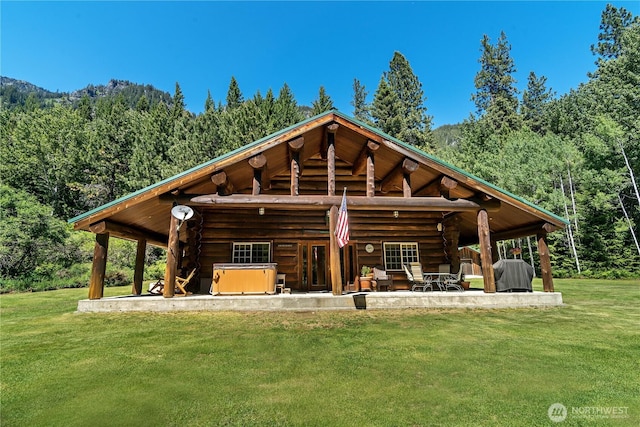 18680 US Highway 2, Lake Wenatchee, WA 98826 - rear view of house with log siding, a wooded view, a hot tub, and a lawn