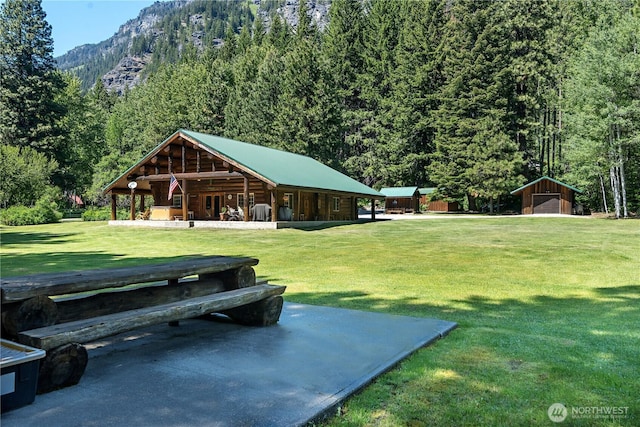 18680 US Highway 2, Lake Wenatchee, WA 98826 - view of home's community with a forest view, a lawn, a mountain view, an outdoor structure, and a garage