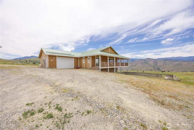 29 Barn Dance Dr, Pateros, WA 98846 - view of front of property featuring covered porch, a garage, dirt driveway, a mountain view, and a metal roof