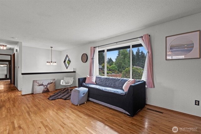 1350 S Woodlawn St, Tacoma, WA 98465 - living area featuring wood finished floors, a chandelier, and a textured ceiling