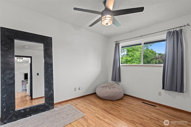1350 S Woodlawn St, Tacoma, WA 98465 - unfurnished room with wood finished floors, ceiling fan, and a textured ceiling