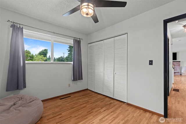1350 S Woodlawn St, Tacoma, WA 98465 - bedroom featuring light wood-style flooring, a closet, a ceiling fan, and a textured ceiling