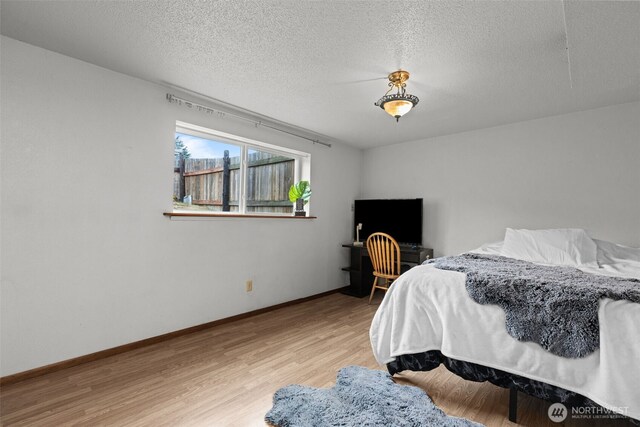 1350 S Woodlawn St, Tacoma, WA 98465 - bedroom featuring wood finished floors and a textured ceiling